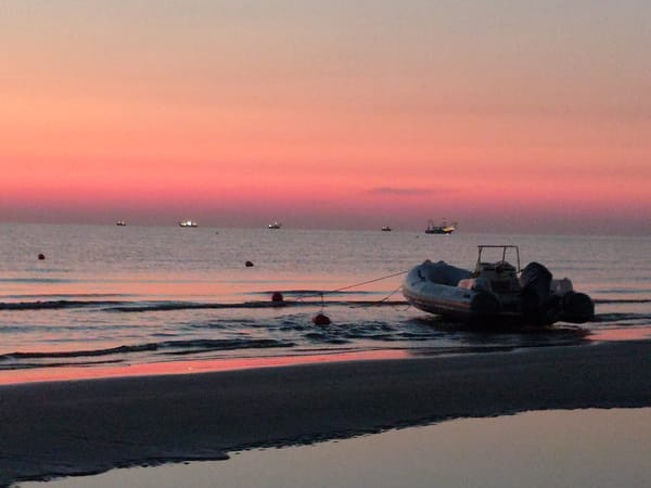 Rimini beach at golden hour, boat on shore