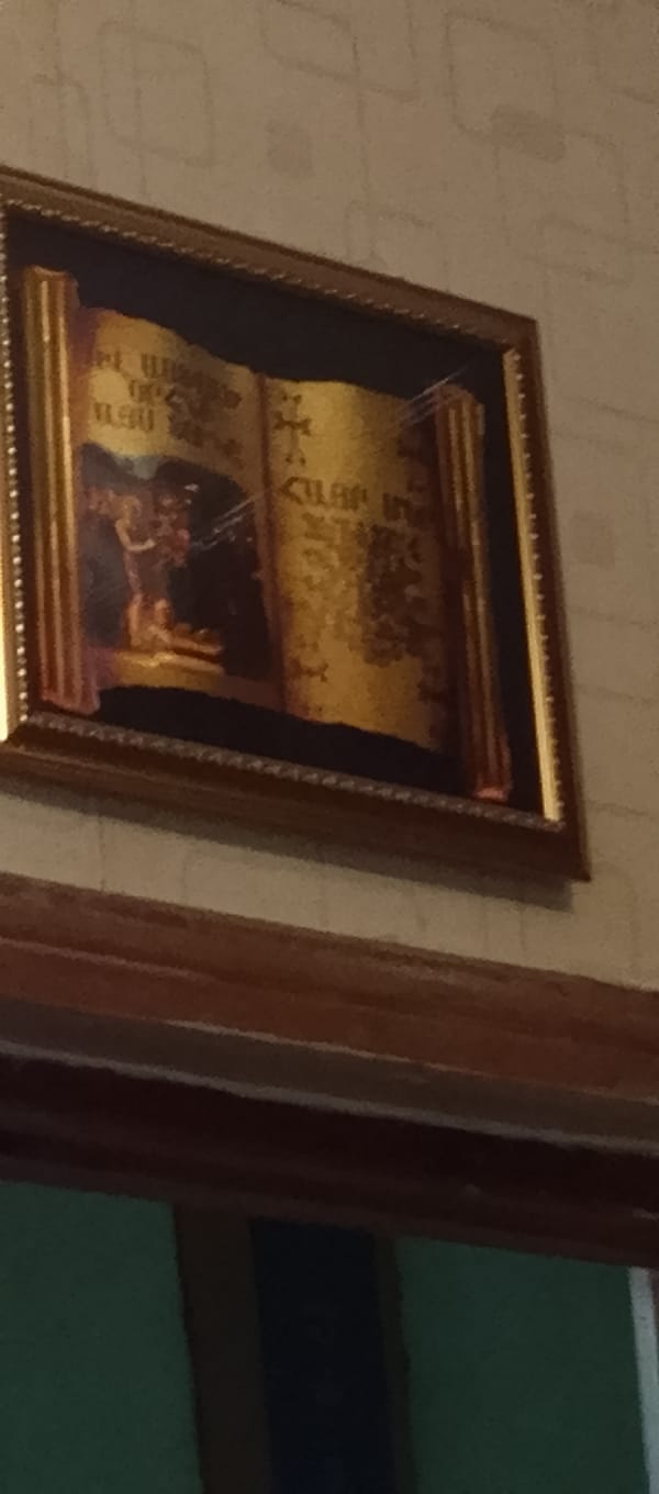Ornate scroll painting with religious figures observed on wall