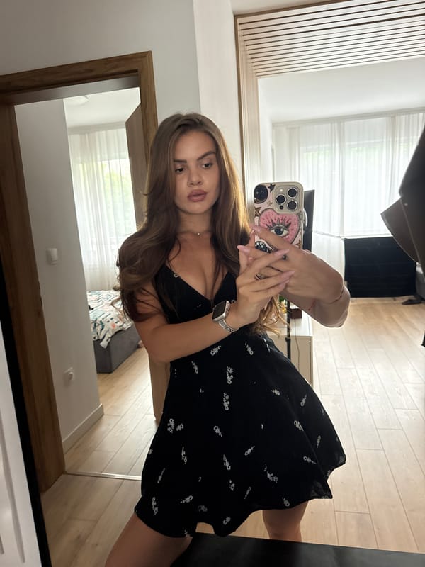 Woman takes mirror selfies in black floral dress
