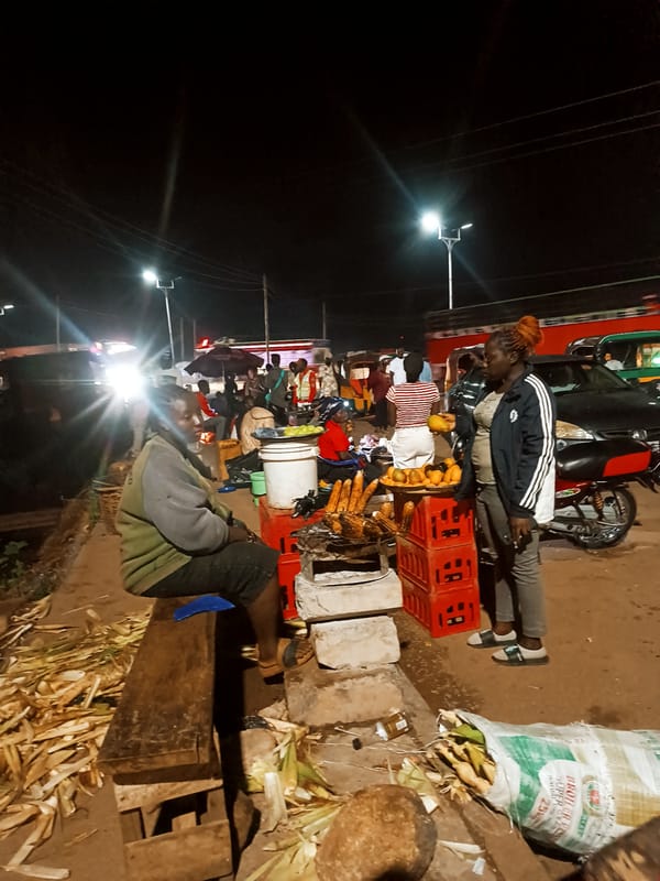 Night market bustles with vendors, overloaded vehicles, pedestrian traffic