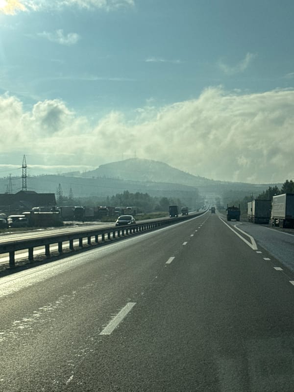 Hazy highway stretching through Revda under an overcast sky.