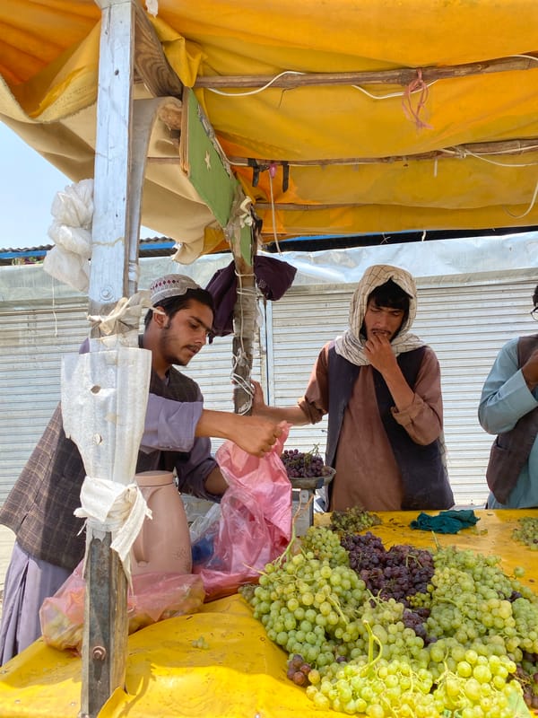 Street commerce and traffic moving through central Kandahar