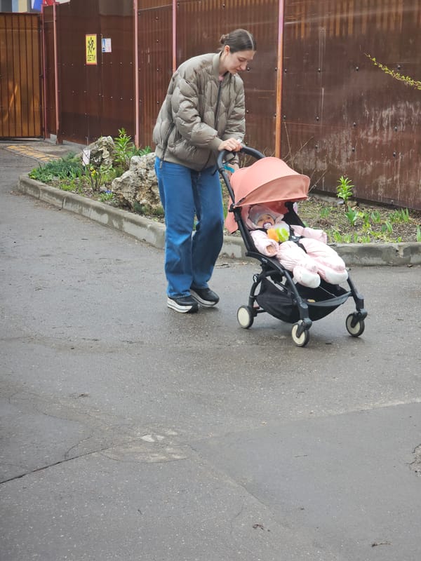 Morning pedestrians navigate wet Moscow streets with stroller, backpack