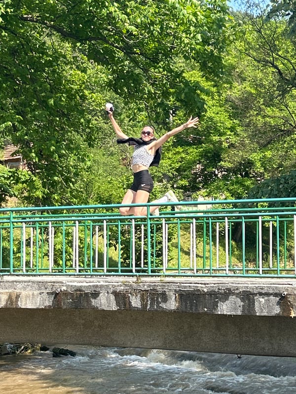 Woman jumps on bridge in rural Bulgaria setting