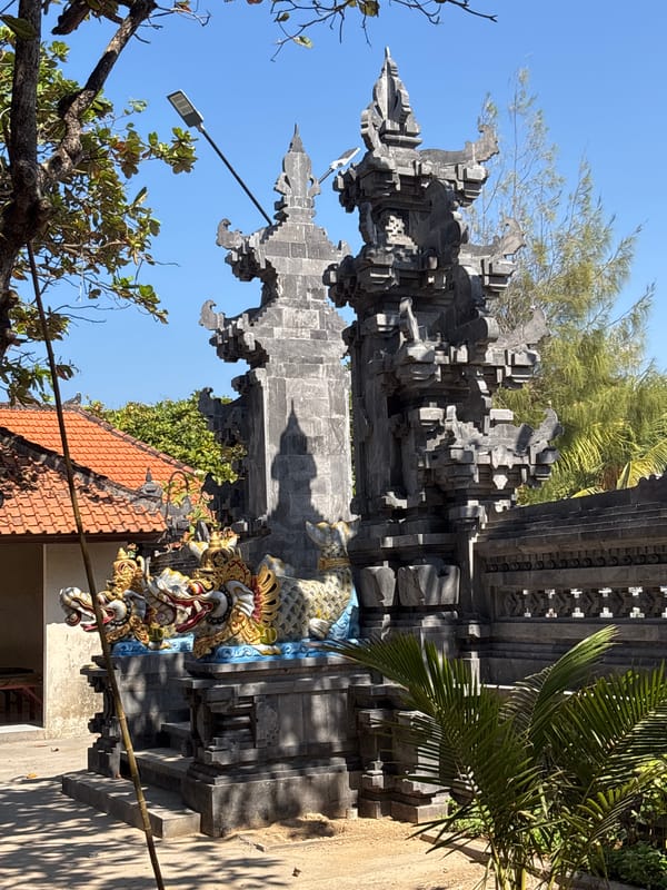 South Bali beachfront life around a carved Balinese gateway