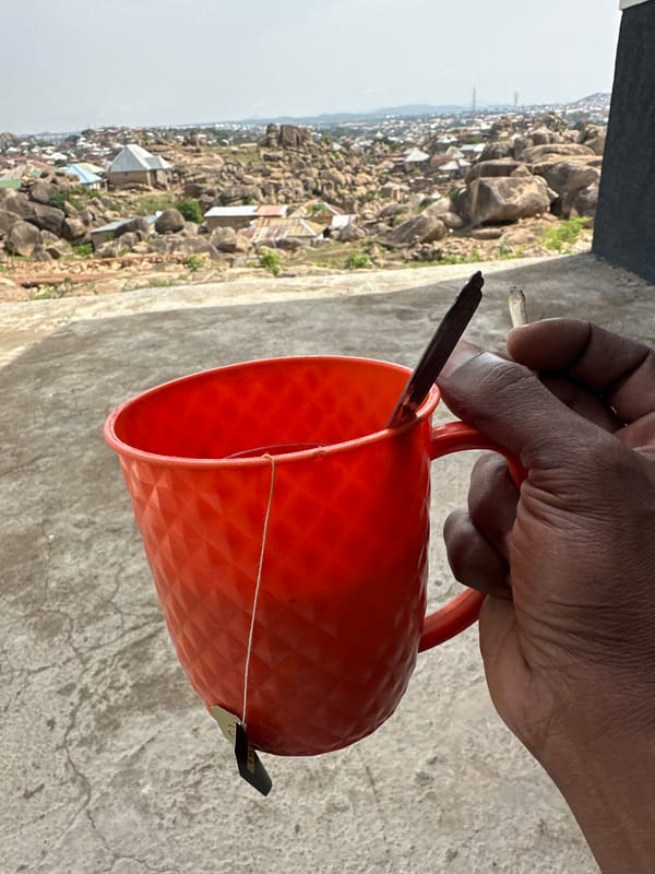 Morning coffee break captured against Jos Nigeria's rocky cityscape