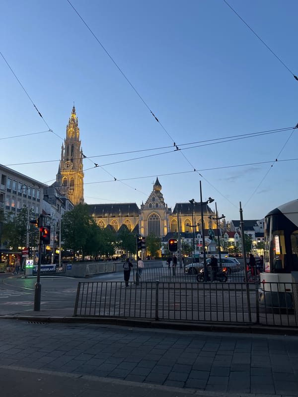 Clear twilight sky illuminates Antwerp cityscape during evening hours