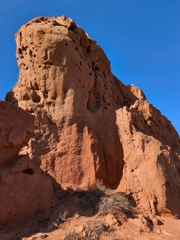 Tourist explores dramatic red rock canyon in Kyrgyzstan