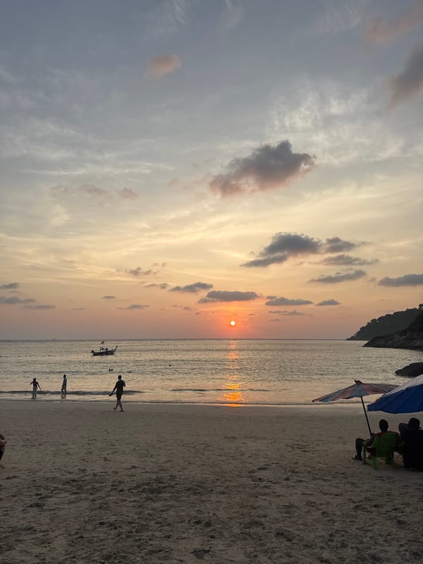 Tourists enjoy sunset hours at busy Patong Beach, Thailand