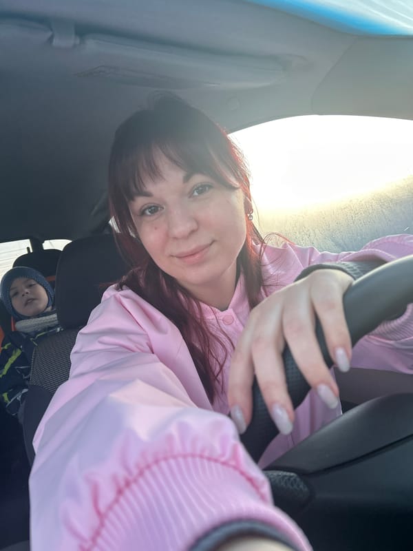 Woman takes car selfies with sleeping child during sunset