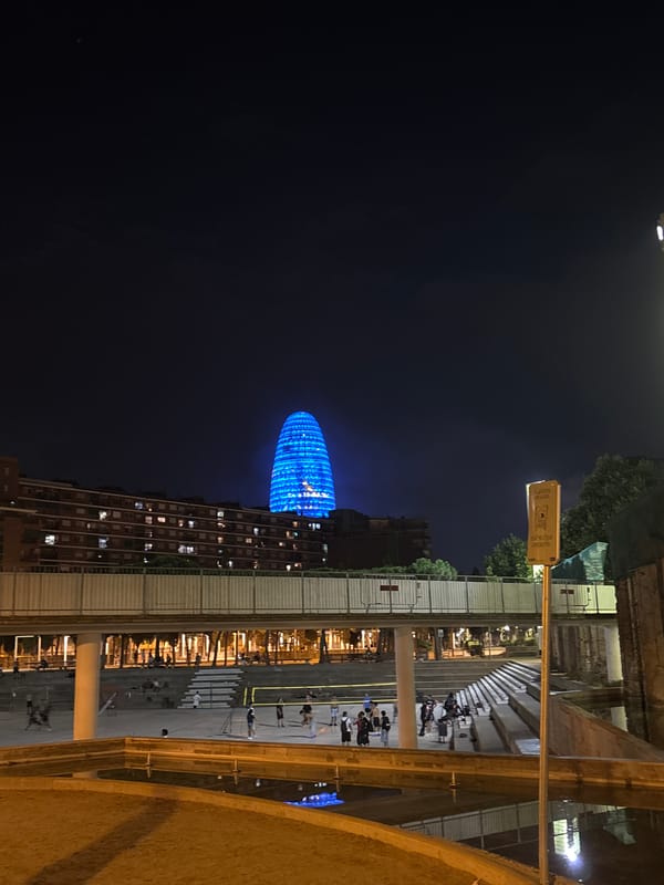 Torre Glòries glowing blue in the Barcelona night