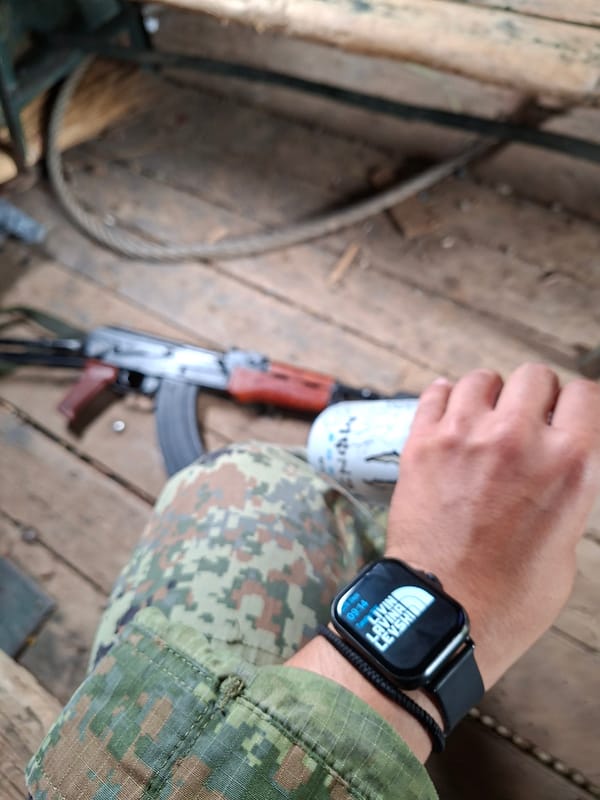 Camo gear and rifle in view from a wooden platform