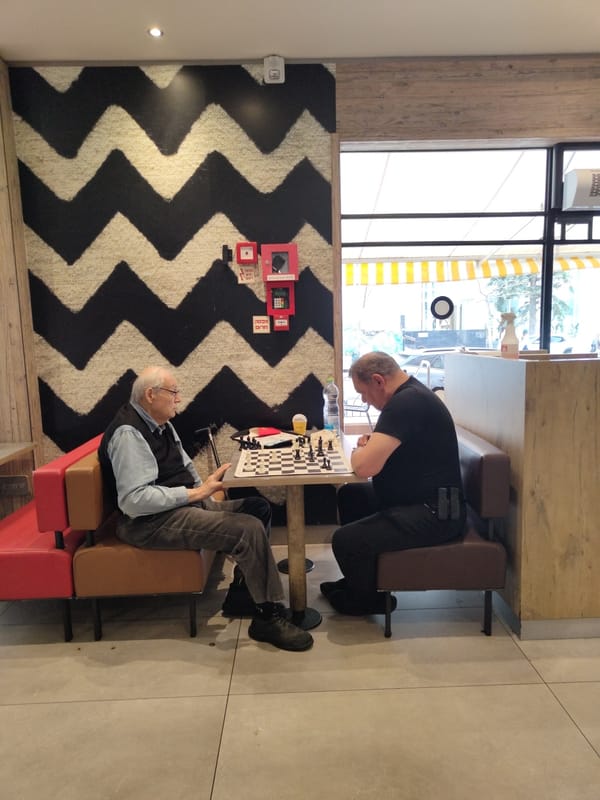 Two men play chess indoors in Al Jizah, Jordan