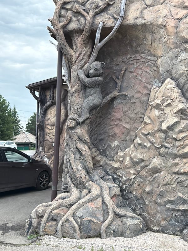 Rustic cafe entrance and bear sculpture in Sukhaya, Russia