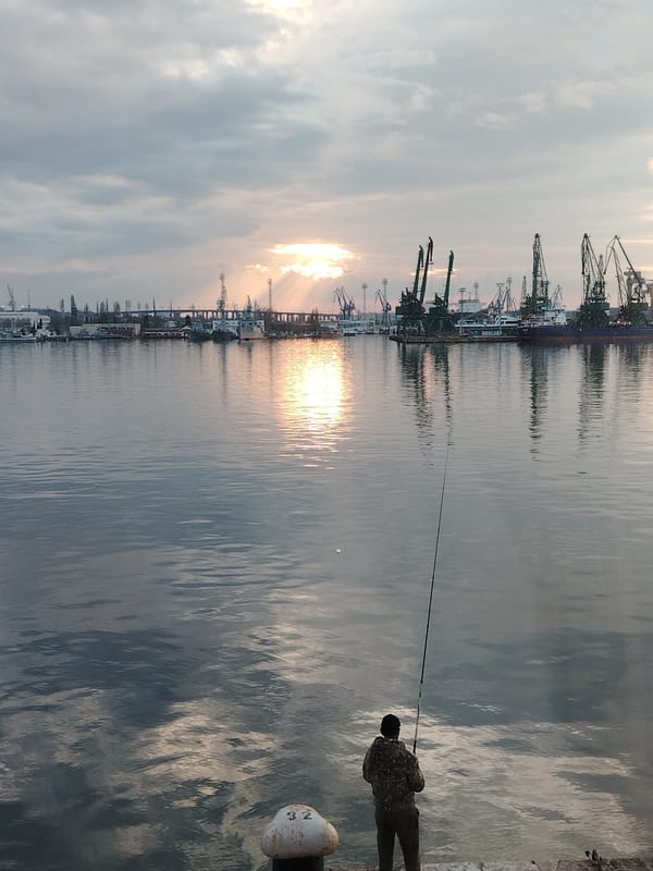 Angler fishes from Port of Varna platform at sunset