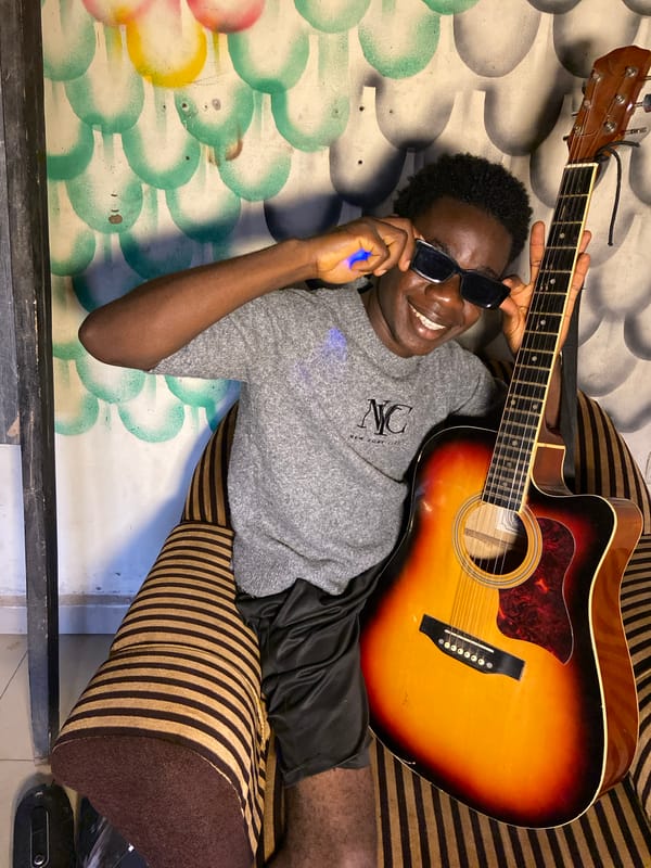 Young musician relaxes with guitar at home in Nigeria