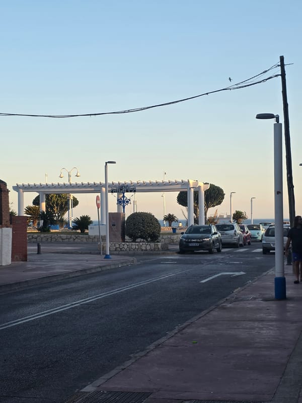Málaga's waterfront at golden hour, beach to port