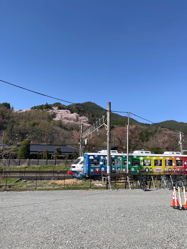 Rainbow character train spotted in Fujiyoshida with mountain backdrop