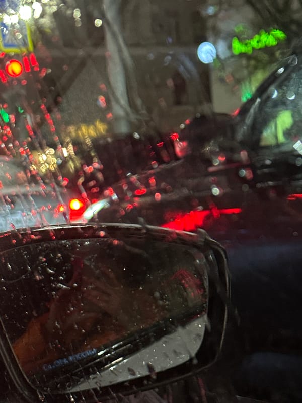 Rainy evening traffic captured through windshield in Ovoshchnoy, Russia