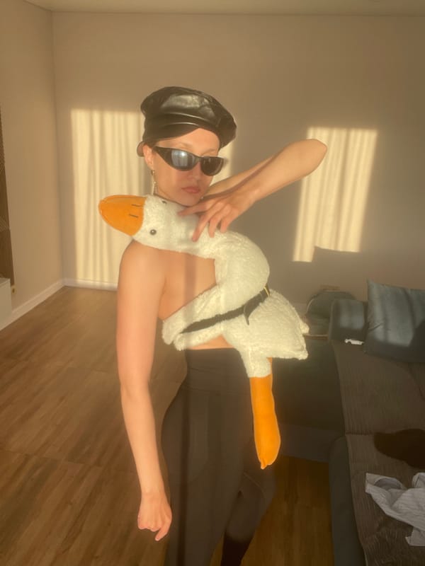 Person poses with giant plush goose in Russian home