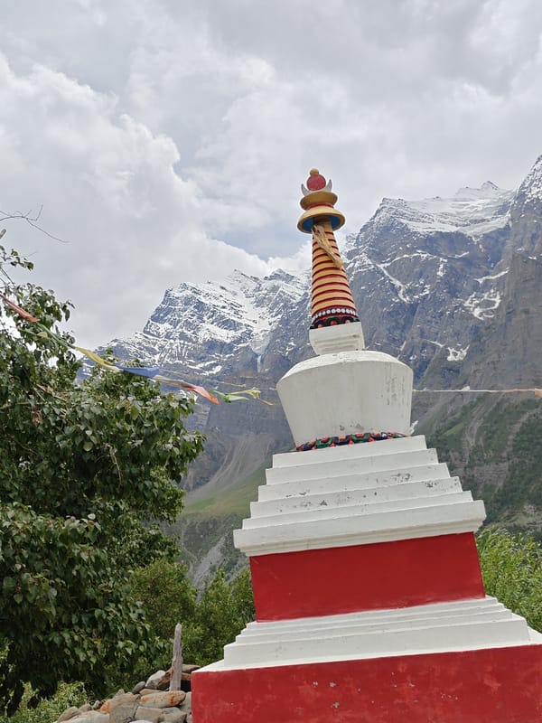 Motorcycle ride past a prayer flag stupa in Himalayan Gondhla
