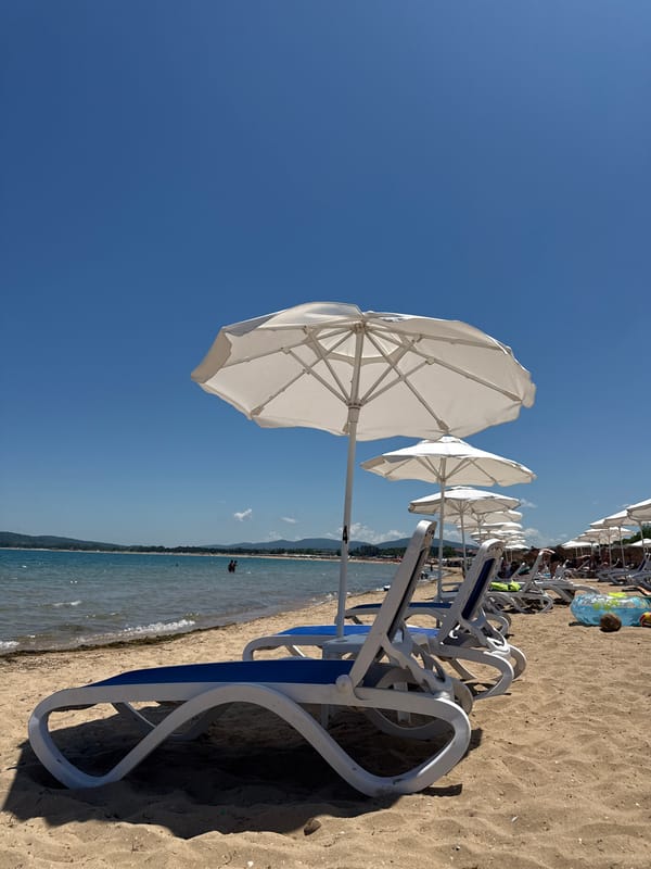 Calm beach day, empty chairs and clear shallow water