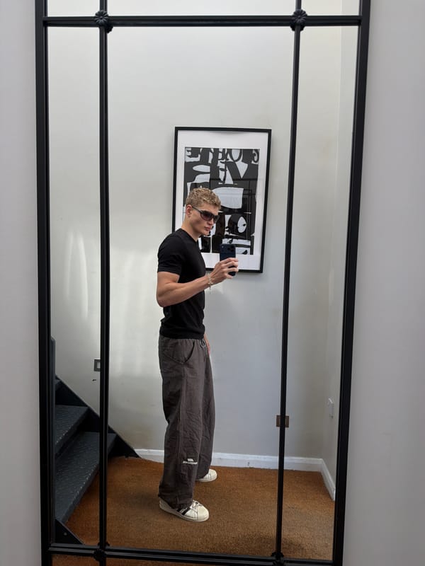 Mirror selfie in a black-framed multi-paned mirror, London