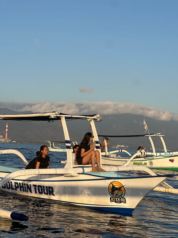 Dolphin tour boats on calm Indonesian coastal waters at sunset