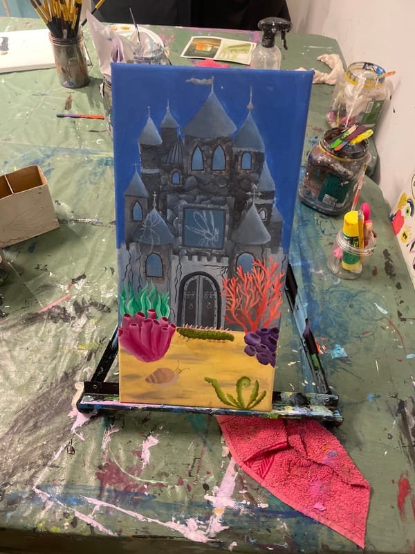 Artist works on castle painting in Raanana studio