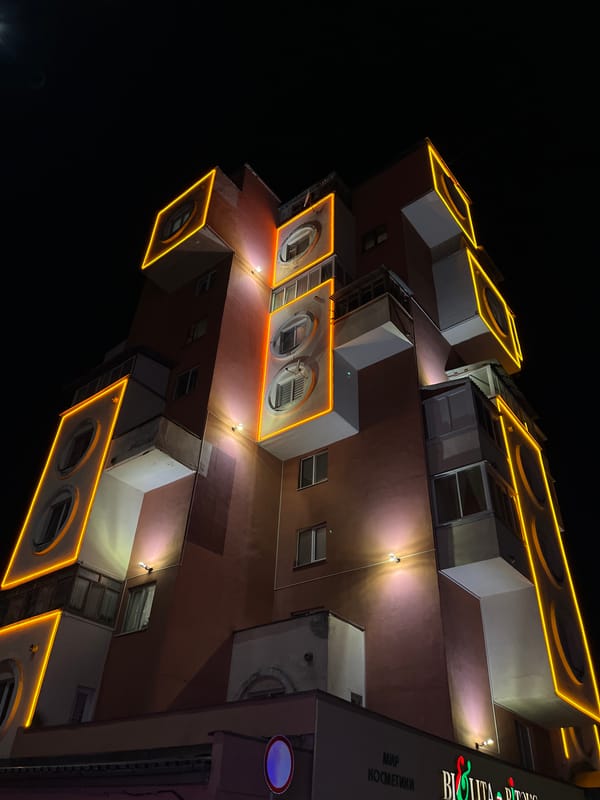 Brutalist apartment block lit up in yellow neon, Babruysk night