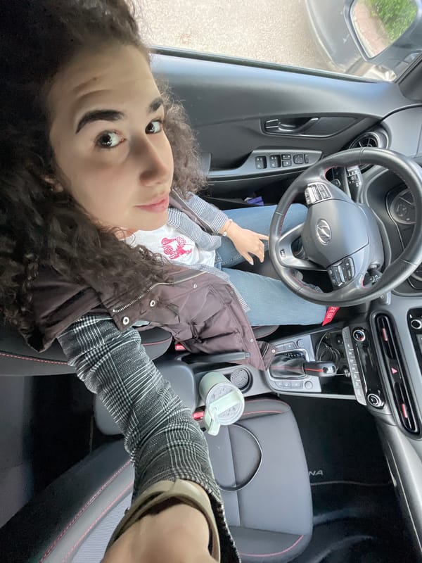 Woman makes peace sign in car, Sofia morning