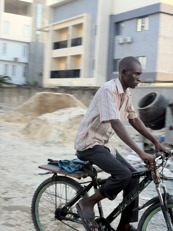 Cyclist spotted on dusty road near modern building in Moba