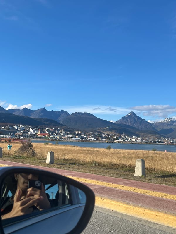 Ushuaia landscape viewed through car mirror shows mountains, water