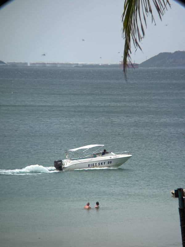 Boats, beach, and bathers on a hazy Vietnamese coast
