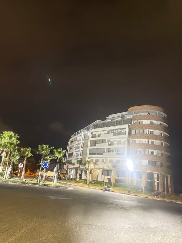 Modern curved residential building photographed at night in Safi