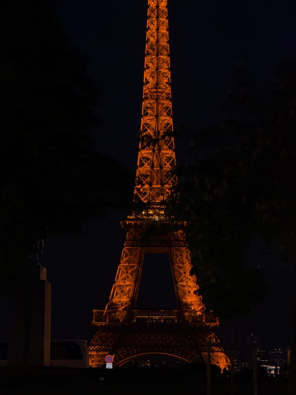 Eiffel Tower glows golden in evening illumination, Paris