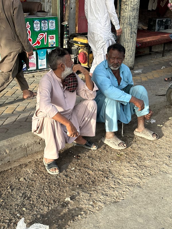 Street market activity in Quetta — shops, phones, and live poultry