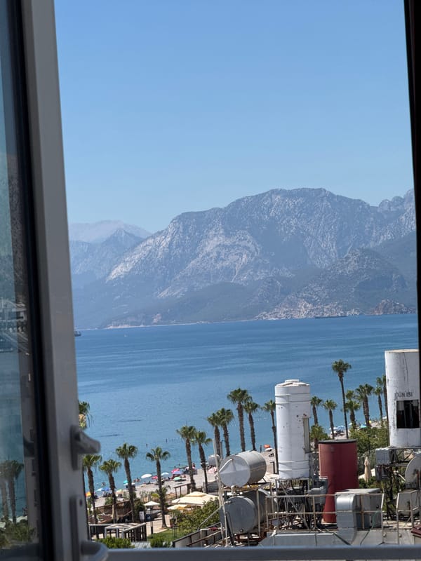 Konyaaltı's beach, hotels, and mountain backdrop on a summer morning