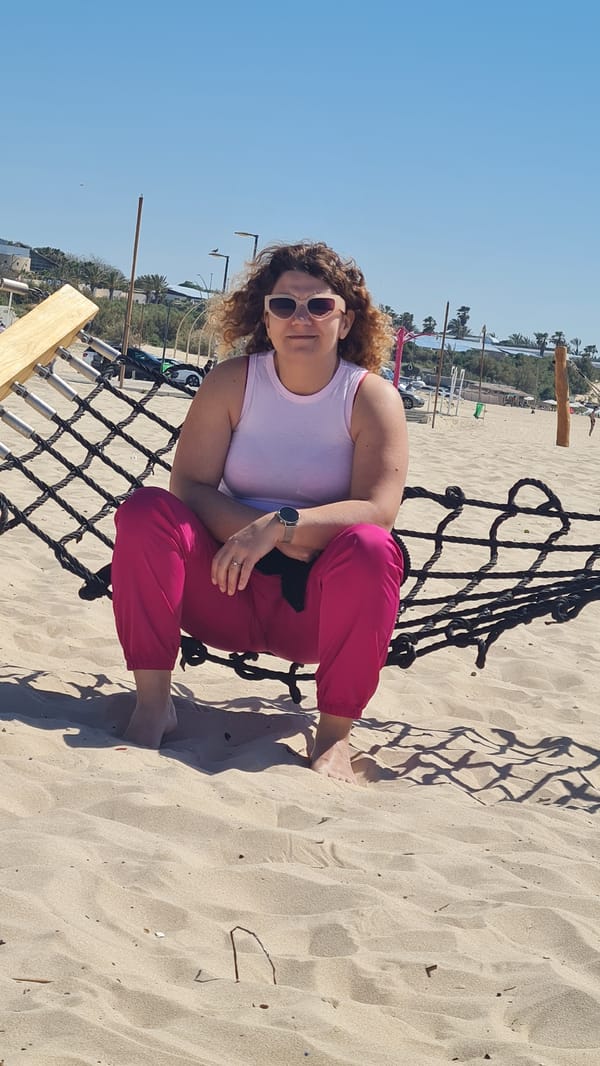 Woman relaxes on beach in Ashkelon under clear skies