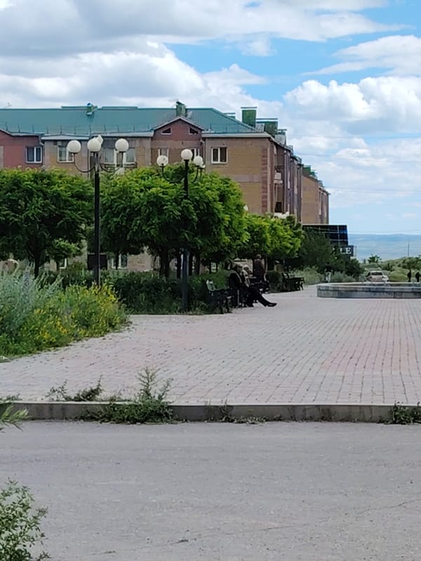 Brick paths, wildflowers, and a stone monument in an urban park