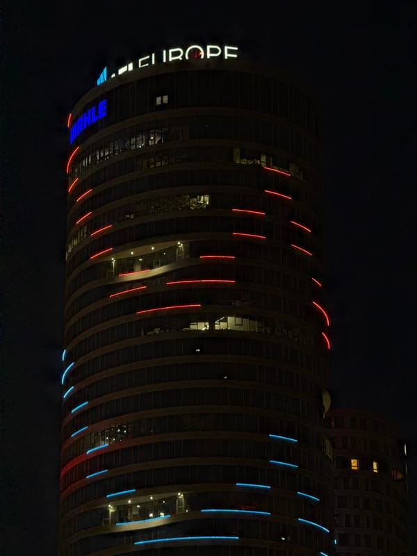 Modern Belgrade high-rise illuminated at night displays curved facade