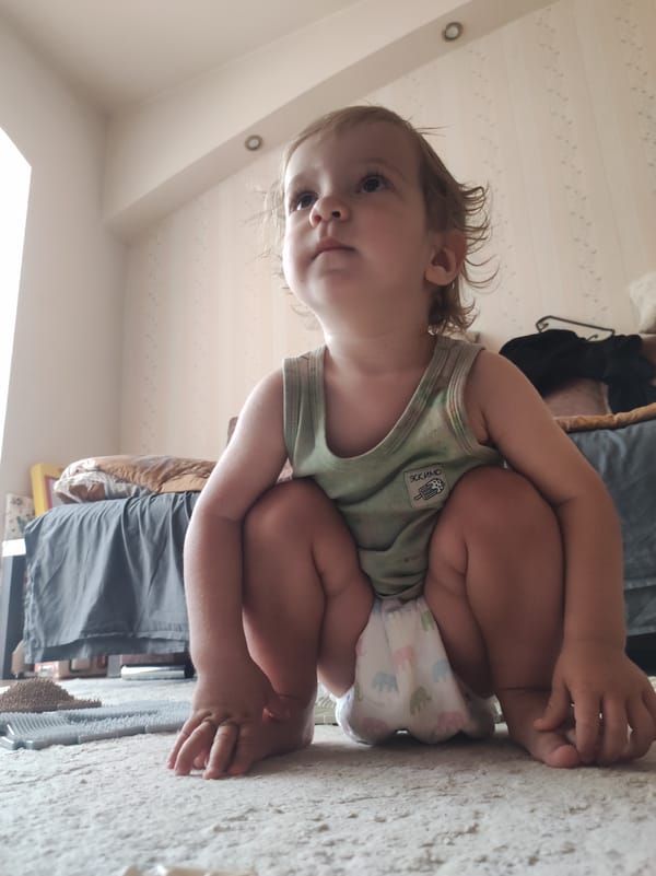 Toddler and poodle share a casual bedroom moment in Russia