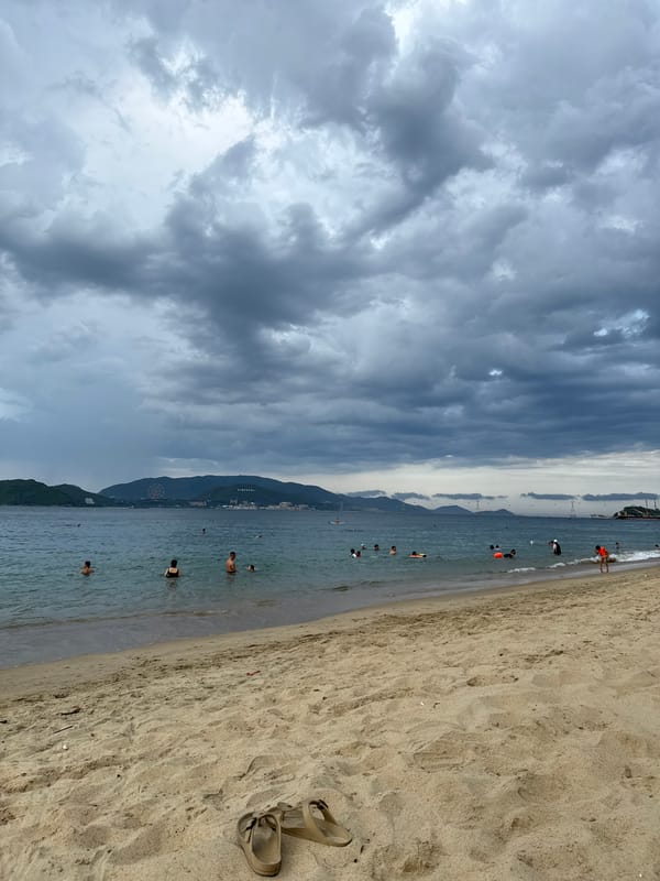Overcast morning at Nha Trang beach — sand, surf, and volleyball