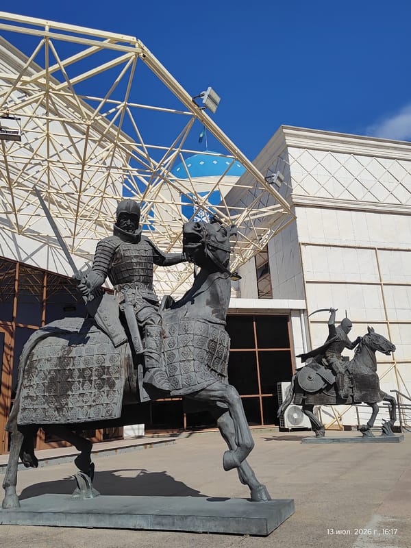 Armored equestrian statues outside a modern Astana building