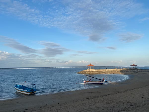 Bali beach walk: boats, carvings, and coastal life in Denpasar