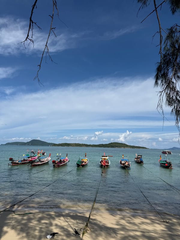 Longtail boats and shoreline stillness at Rawai Beach