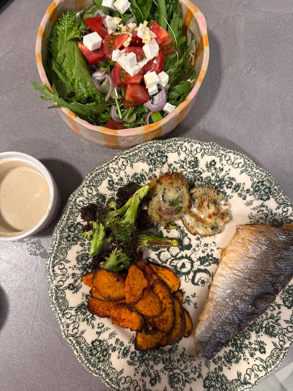 Home-cooked meal documented featuring fish, vegetables, and potato cakes