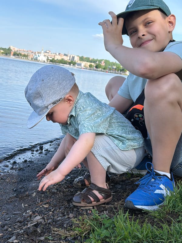 Children play at Votkinsk Reservoir shoreline near cathedral