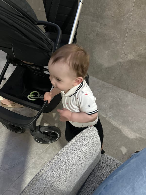 Toddler explores downtown Chișinău near modern buildings and restaurant