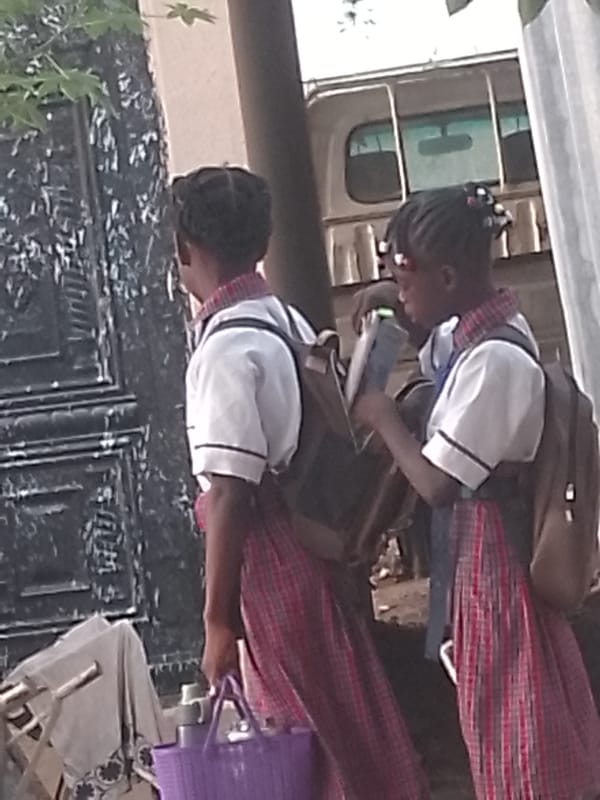 Morning street scenes captured: schoolchildren, pedestrians, parked motorcycle